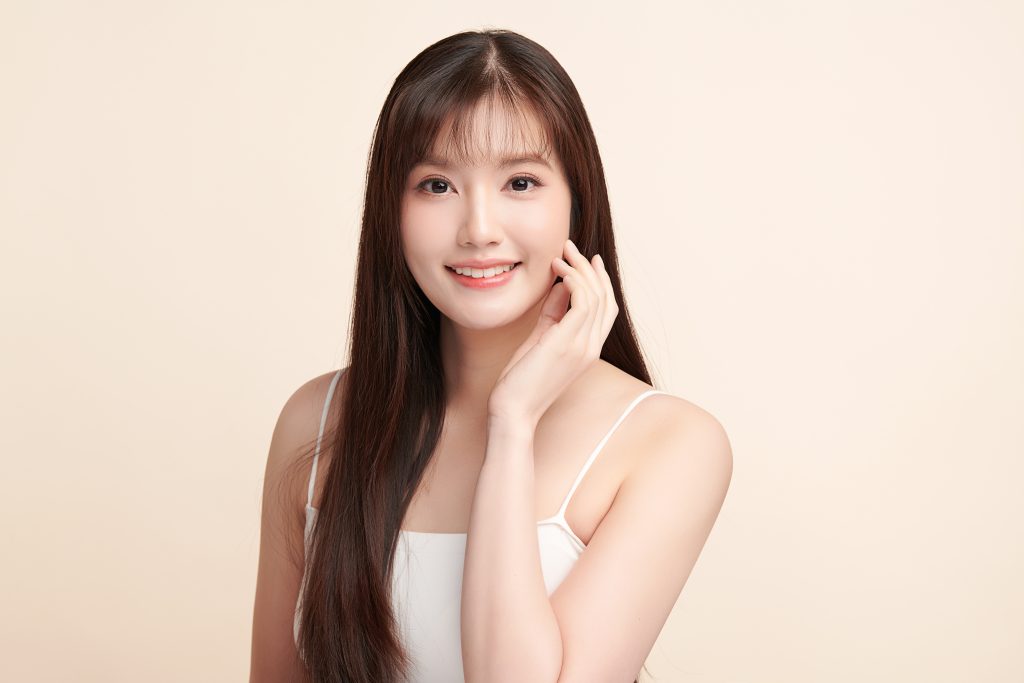 年輕亞洲女性輕扶臉頰、露出自然微笑的臉部菲斯波拉提示意照