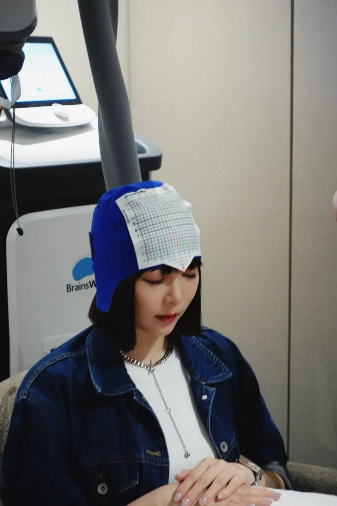體驗者配戴定位帽準備進行 Deep TMS 非侵入式神經調節療程