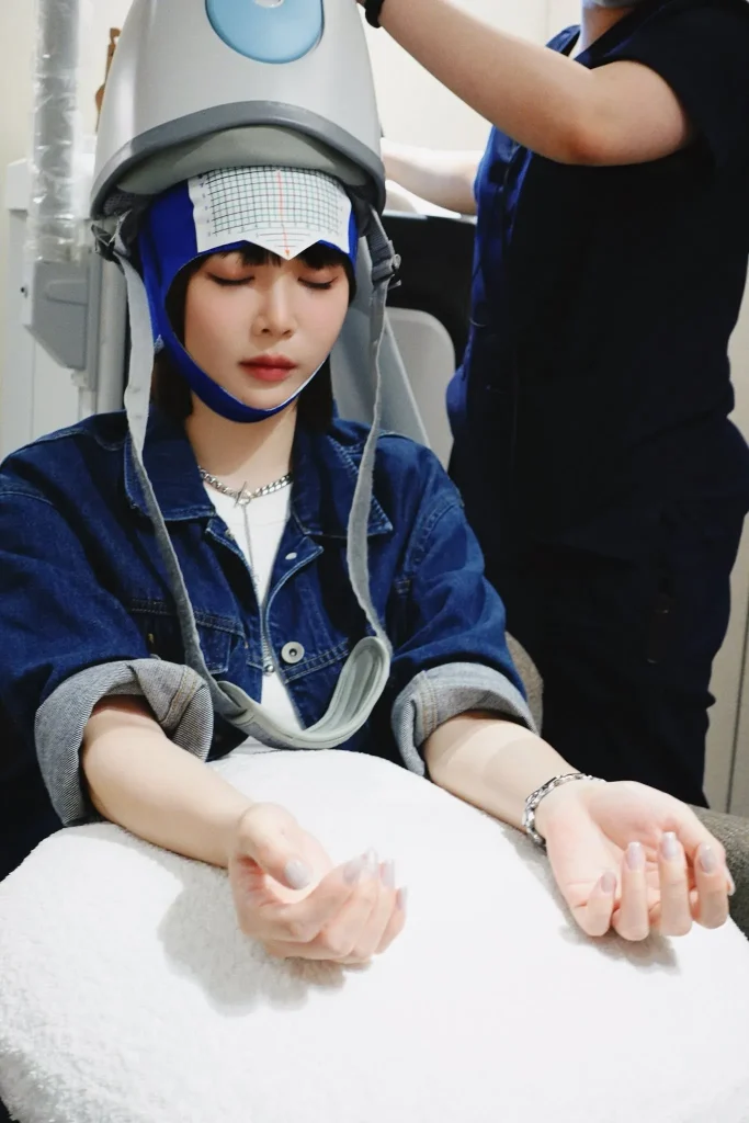 體驗者閉眼坐在治療椅上接受 Deep TMS 睡眠療程